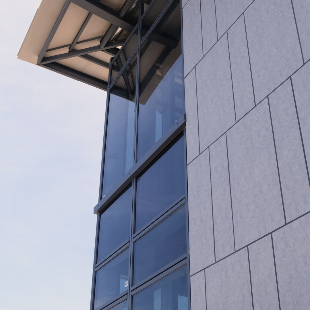 This picture shows a corner glass window with black panels.
