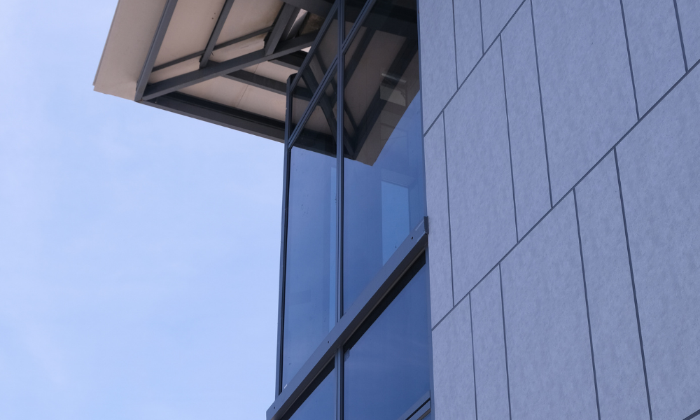 This picture shows a corner glass window door with gray panels.