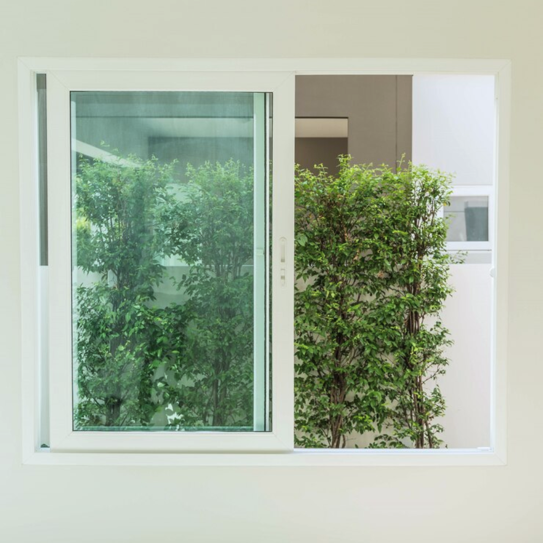 This picture shows a sliding glass window with white panels in a residential home.